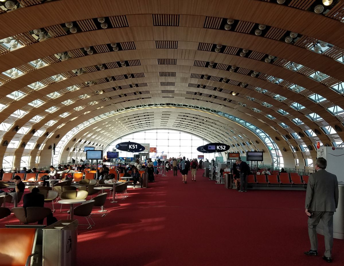 Viajeros caminando por una terminal de salidas del aeropuerto París-Charles de Gaulle