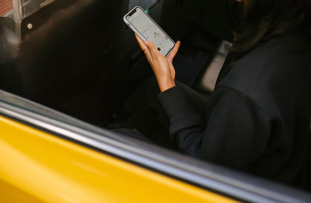 Takside telefonundaki harita uygulamasına bakan bir yolcu