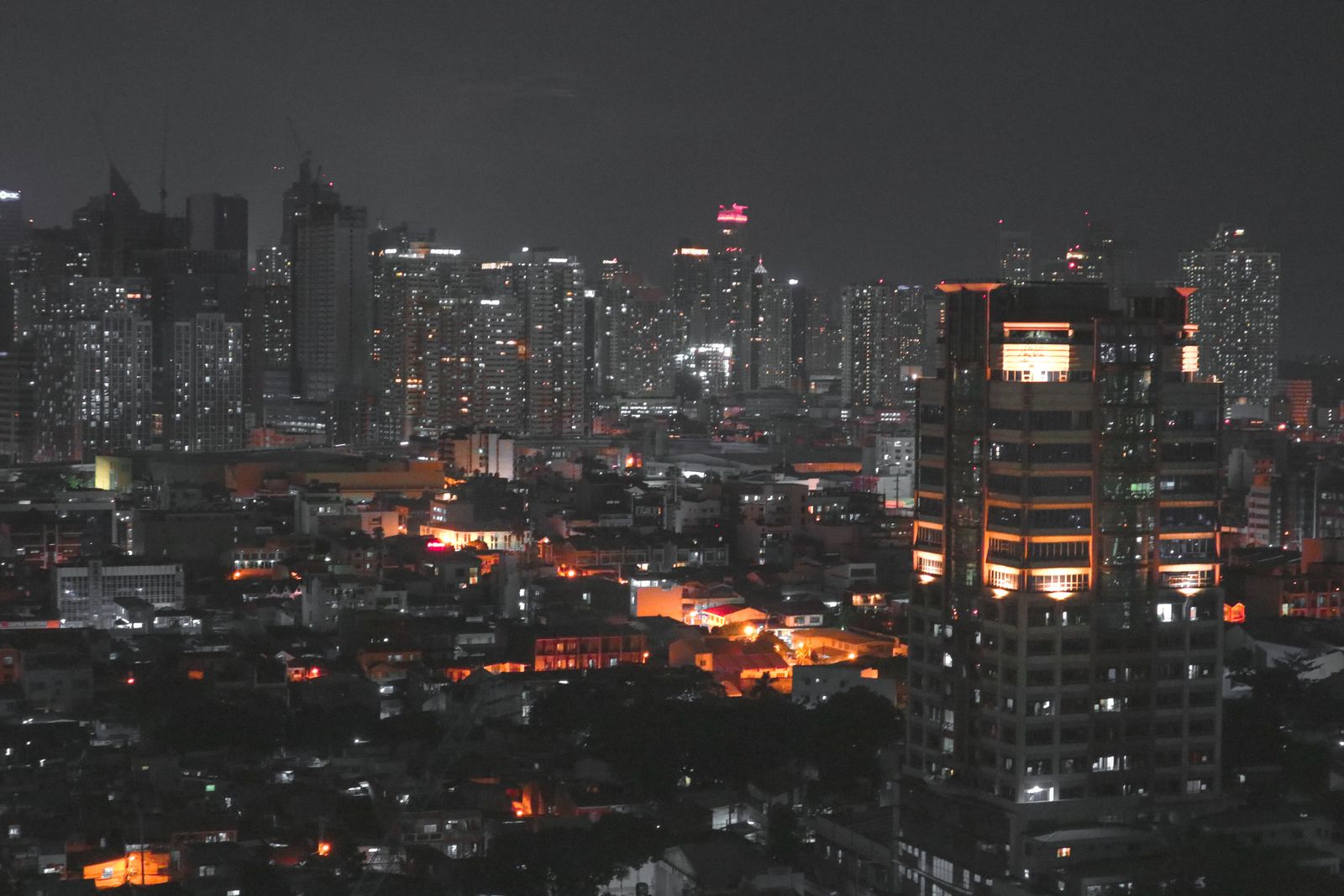 Vista aérea de los rascacielos de Manila iluminados de noche